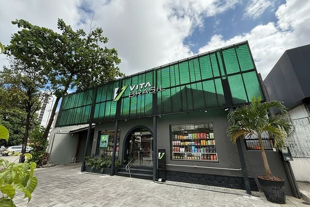 Fachada de uma terceira loja VitaBrasil, com estrutura de tela verde e entrada em arco.